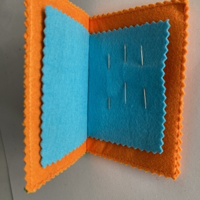 Estojo de feltro laranja e azul com agulhas de costura