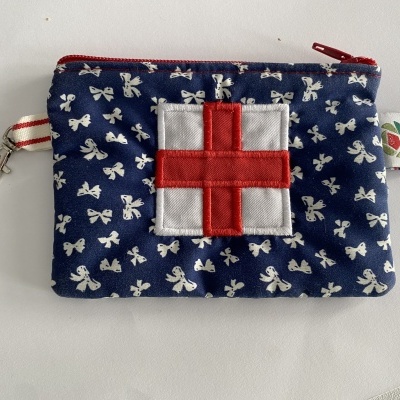 Bolsa pequena azul com laços brancos e símbolo de cruz vermelha