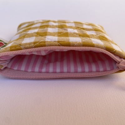 Bolsa pequena acolchoada xadrez amarelo e branco com fecho de correr rosa e interior riscado rosa e branco