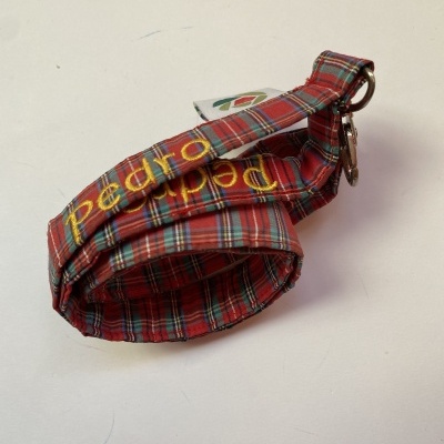 Coleira para cão em tecido vermelho com padrão quadriculado e texto impresso