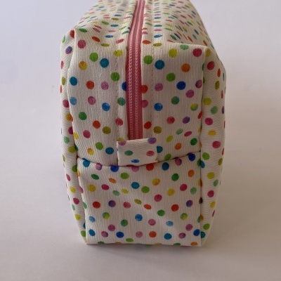 Estojo retangular com padrão de bolinhas coloridas e fecho rosa