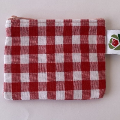 Bolsa pequena padrão xadrez vermelho e branco com fecho zip e etiqueta com logótipo.