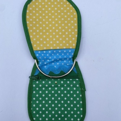 Estojo tecido verde de bolinhas com interior amarelo e azul, faixa metálica e fecho de correr