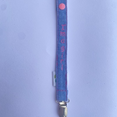 Prendedor de fita azul ganga com botão rosa e clip metálico, texto 'I'm a girl' bordado