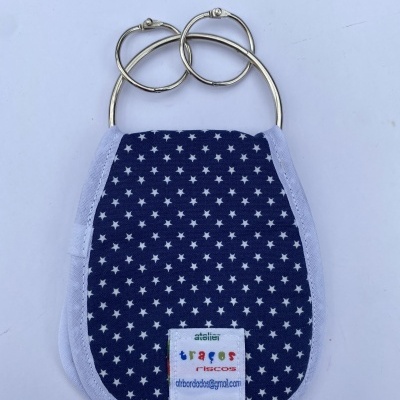 Prendedor de chucha azul com estrelas brancas e etiqueta com texto, suportes metálicos redondos