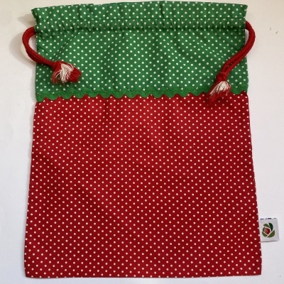 Saco de tecido com cordão verde e vermelho e padrão de pontos brancos