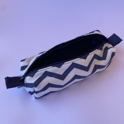Estojo retangular com padrão zig-zag preto e branco e fecho preto