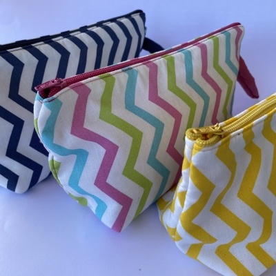 Três necessaires de tecido com padrão zigzag em várias cores