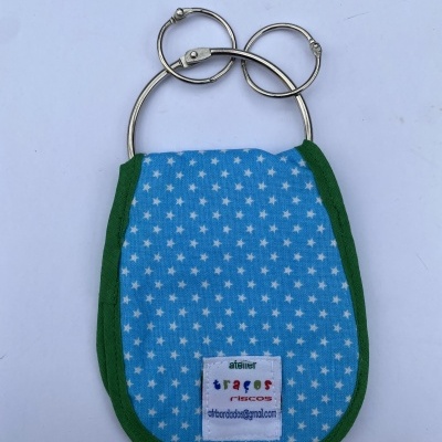 Porta-chaves de tecido azul com estrelas brancas e bordas verdes.
