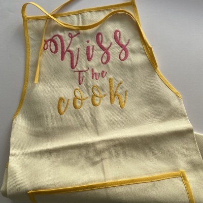 Avental de cozinha creme com bordas amarelas e texto bordado