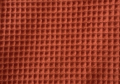 Tecido castanho alaranjado com padrão de colmeia