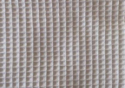 Padrão tridimensional em relevo, cor bege clara, textura regular em linhas verticais