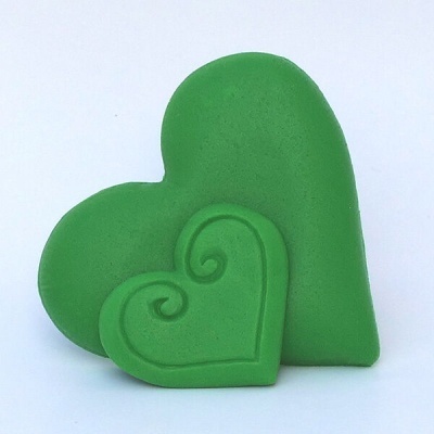 Dois corações decorativos verdes, um com relevo em espiral, sobre fundo branco