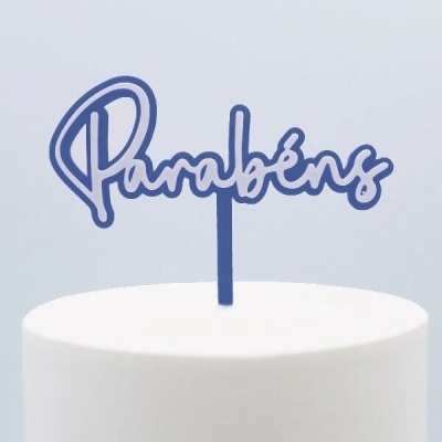 Topo de bolo azul com a palavra 'Parabéns' em caligrafia sobre bolo branco