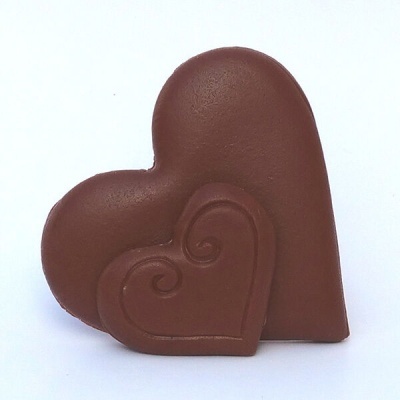 Dois chocolates em forma de coração, um maior e um menor gravado com espirais