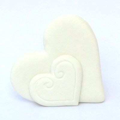 Dois corações brancos, um maior e outro menor, com relevo