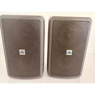 Par de colunas cinzentas com grelha metálica e logótipo azul e branco