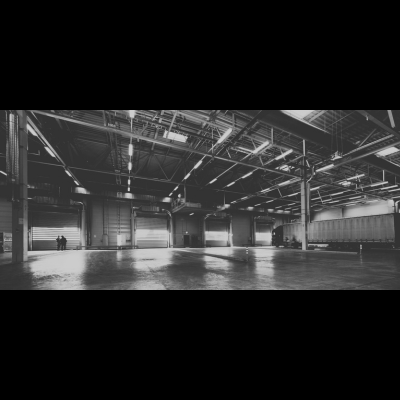 Armazém espaçoso com portas de carregamento e camião estacionado