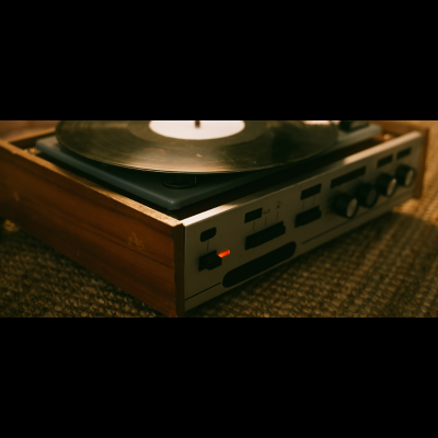 Toca-discos vintage com madeira e metal prateado, com botões e luz laranja.