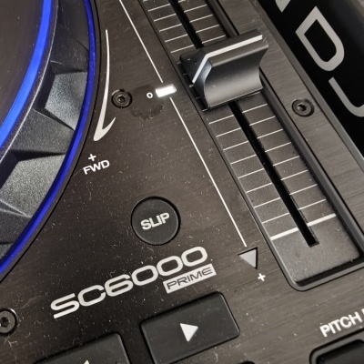 Controlador DJ preto SC6000 Prime com botões, slider e iluminação azul