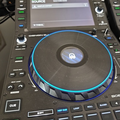 Controlador DJ Denon DJ SC5000 preto com jog wheel iluminada a azul e ecrã tátil