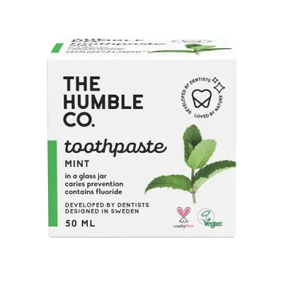 Embalagem branca de pasta de dentes The Humble Co. sabor menta com folhas verdes e informações em preto.