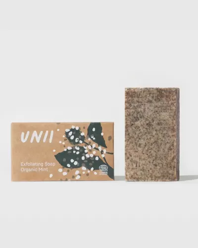 Sabonete esfoliante Organic Mint UNII com embalagem castanha e folhas escuras