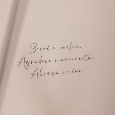 Texto caligráfico preto em fundo bege claro com a frase motivacional em português.