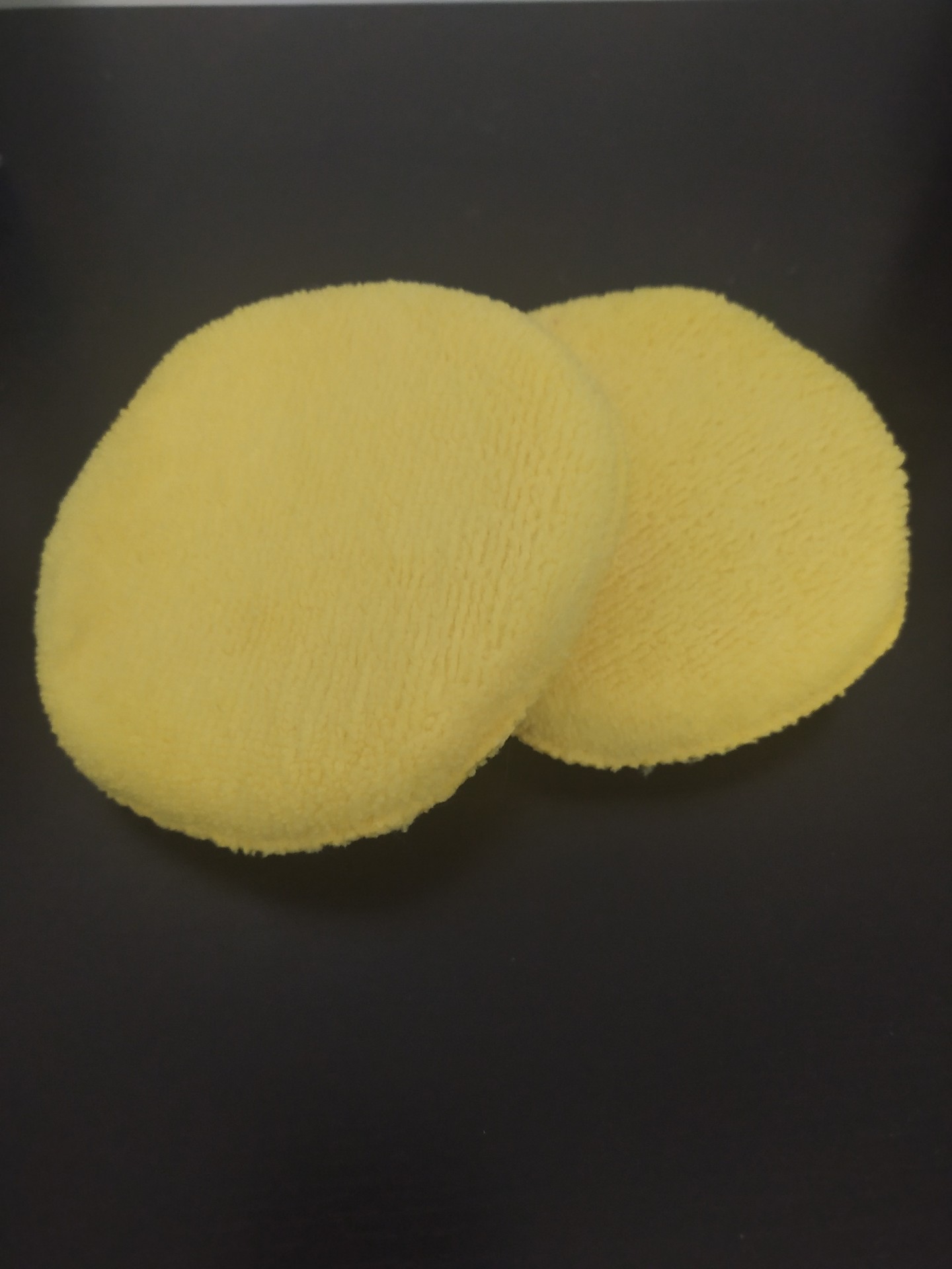 Discos amarelos felpudos sobre superfície preta