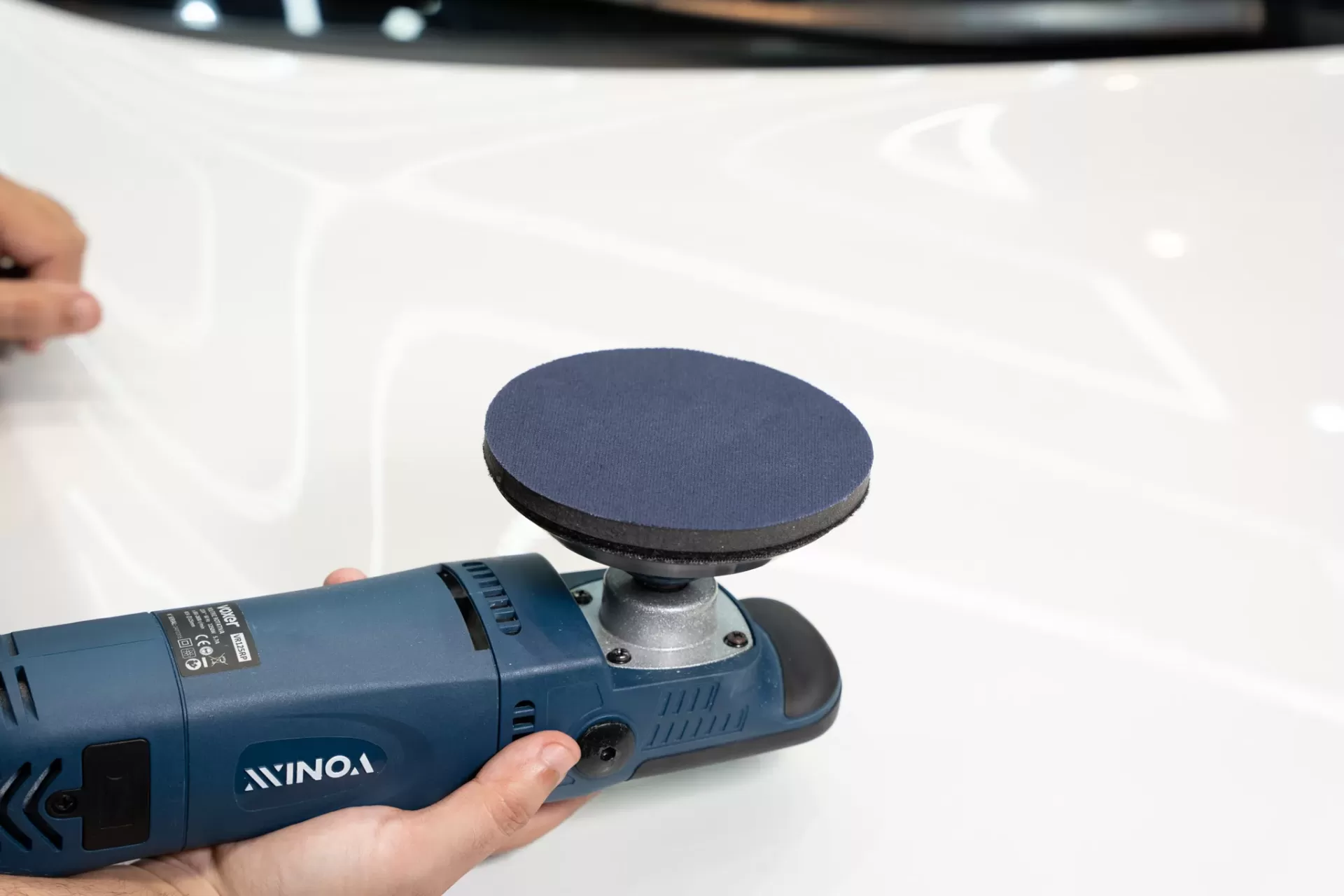 Lixadora/polidora elétrica azul YONIX com disco preto sobre superfície branca