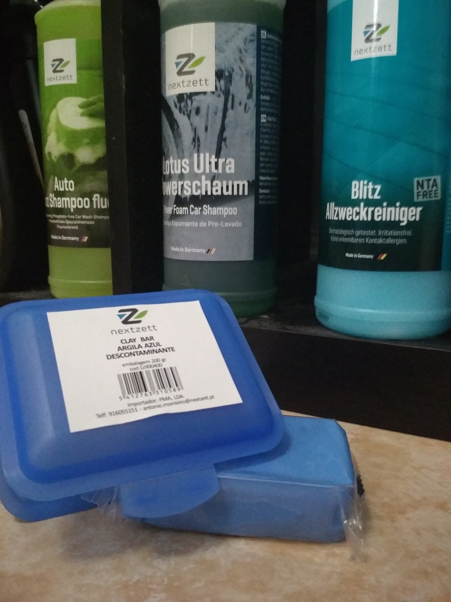 Produtos de limpeza automóvel Nextzett com frascos e barra de argila azul