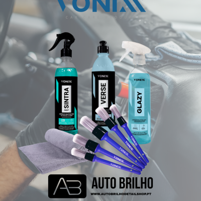 Produtos de limpeza para carro Vonixx com frascos spray azuis, pincéis de detalhe azuis e pano de microfibra lilás em mão sobre volante