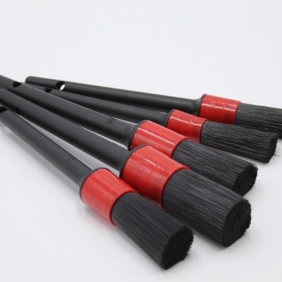 Conjunto de cinco pincéis com cabos pretos e detalhes vermelhos