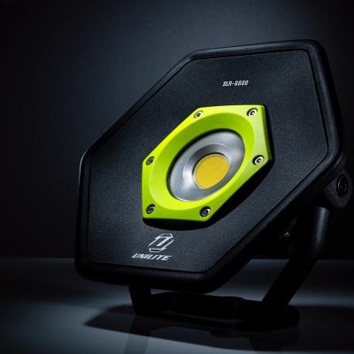 Coluna de som preta e amarela em suporte sobre fundo escuro