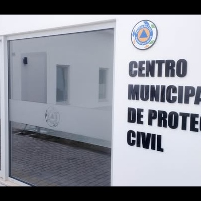 Entrada do Centro Municipal de Proteção Civil com porta de vidro e texto na parede branca
