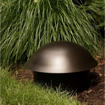 Coluna de som arredondada metálica em jardim com relva e plantas altas