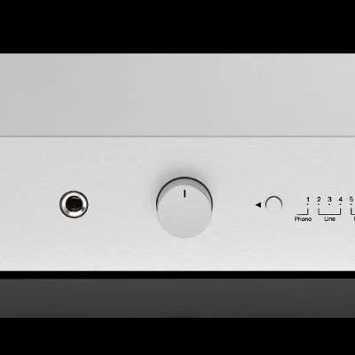 Aparelho áudio branco com botões e entradas jack sobre superfície preta