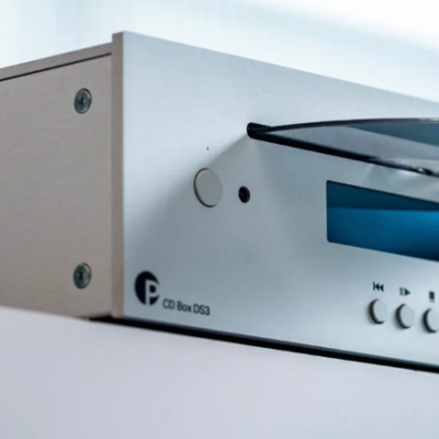 Leitor de CD prateado com visor digital azul e bandeja aberta