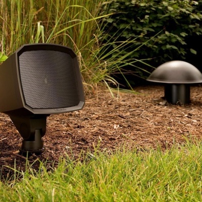 Equipamentos de jardim pretos em solo com mulch e relva verde ao fundo