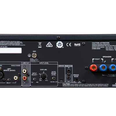 Painel traseiro de amplificador de áudio preto com várias conexões e textos técnicos