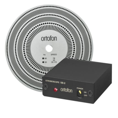 Disco branco com padrões circulares pretos e caixa preta com botões e luzes, ambos da marca ortofon.