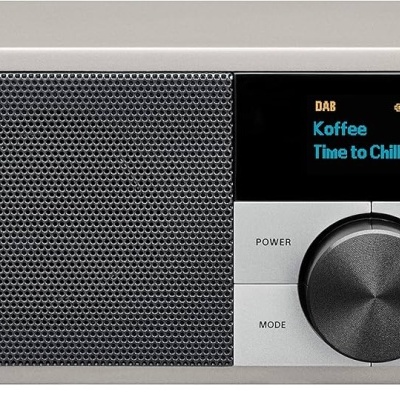 Rádio digital compacto cinza com ecrã colorido mostrando texto e botões de controlo