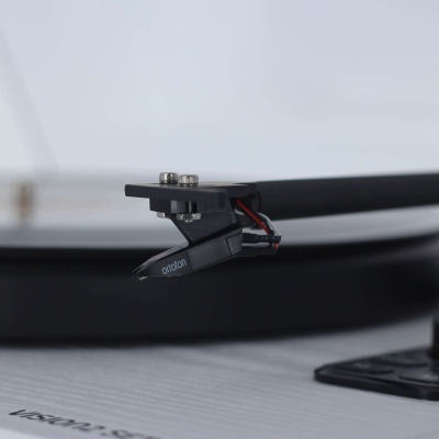 Braço de gira-discos preto com agulha Ortofon sobre gira-discos branco