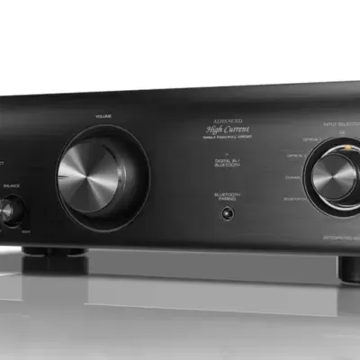 Amplificador preto Denon com botões e texto legível em metal escovado