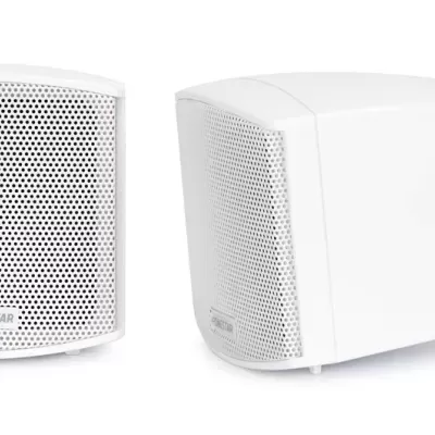 Duas colunas de som brancas com grelha perfurada e fixação de parede