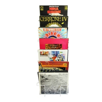 Capas de discos de vinil coloridas e variadas empilhadas na estante.