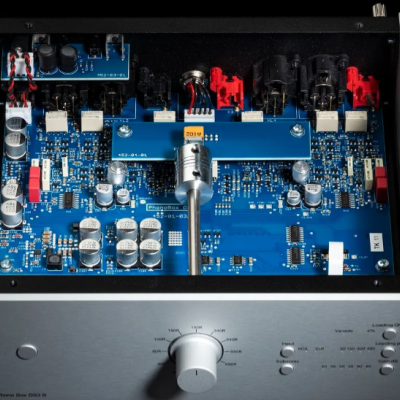 Interior de equipamento eletrónico com placas azuis e painel frontal prateado com botão e marcações