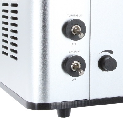 Detalhe do painel lateral de equipamento metálico com dois interruptores e botão pretos