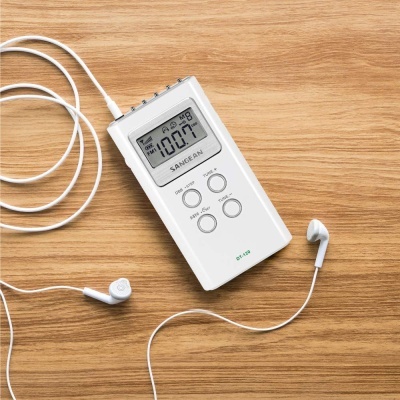 Aparelho digital branco com ecrã e auriculares sobre superfície de madeira