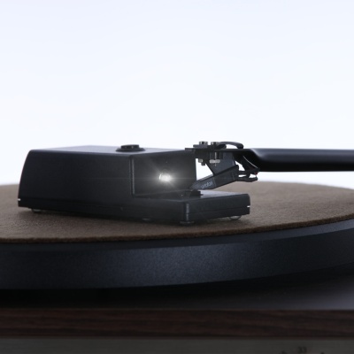 Braço preto de gira-discos num prato com base preta e superfície castanha